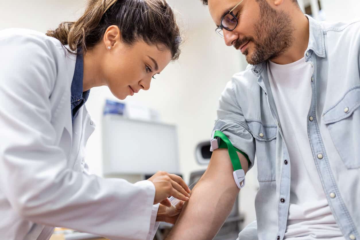A female doctor drawing blood from a male patient