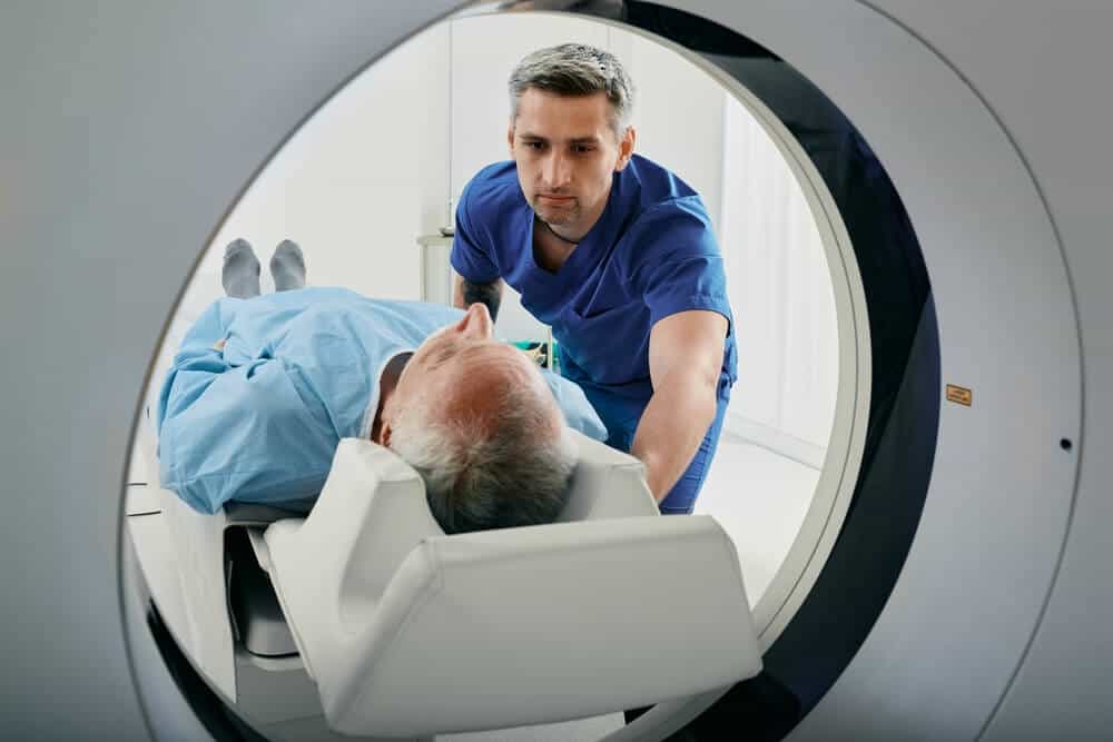A senior man going into a CT scanner.