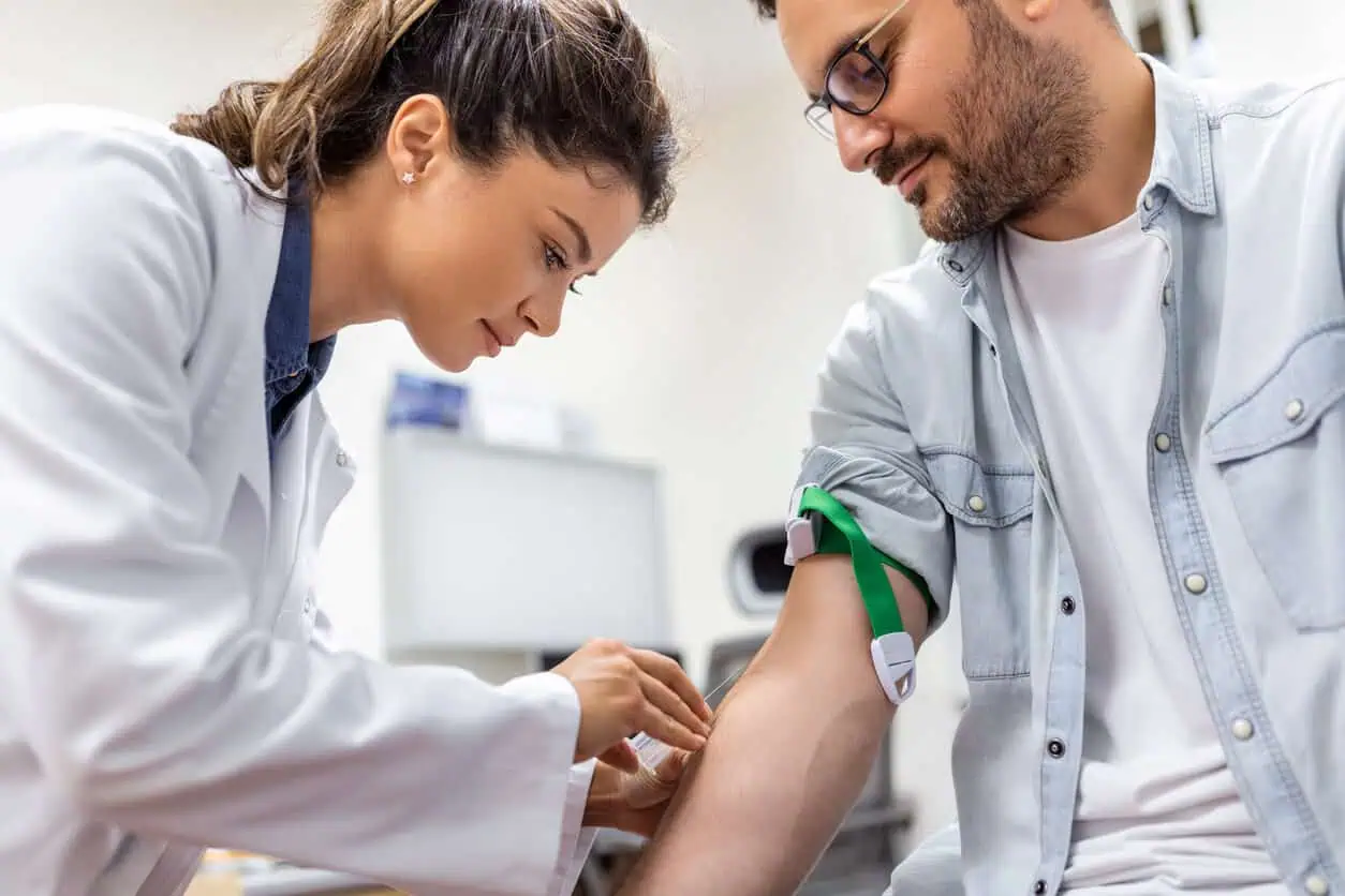 A female doctor drawing blood from a male patient